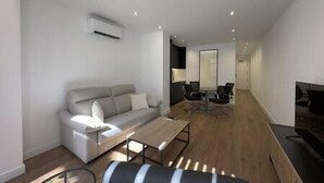 Un salon moderne avec un canapé, une table basse et un téléviseur.