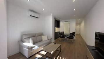 A modern living room with a sofa, coffee table, and a TV.