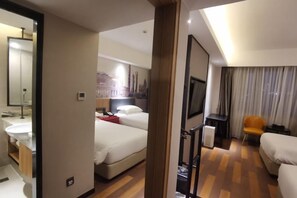 A hotel room with a bed, a desk, a chair, a TV, and a bathroom with a mirror and sink. - Pudong Fute Hotel (Xiepu Road Subway Station) (Shanghai)