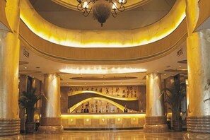 A lobby with marble columns, a reception desk, and a chandelier. - Pudong Fute Hotel (Xiepu Road Subway Station) (Shanghai)