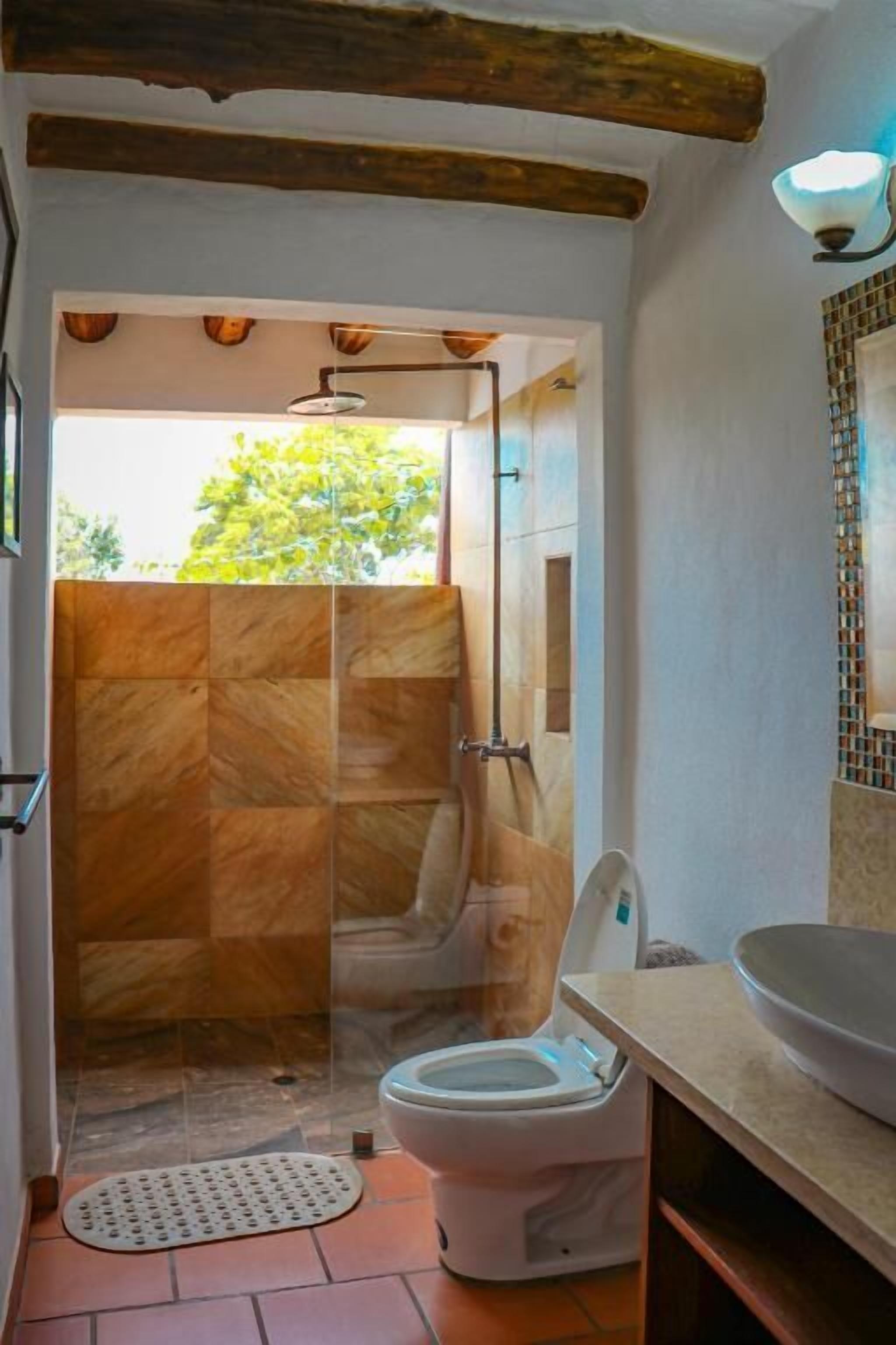 Un baño con ducha, inodoro y lavamanos.