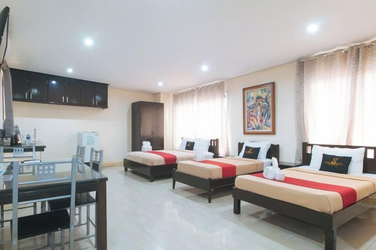 Una habitación de hotel con dos camas, un escritorio y una silla.