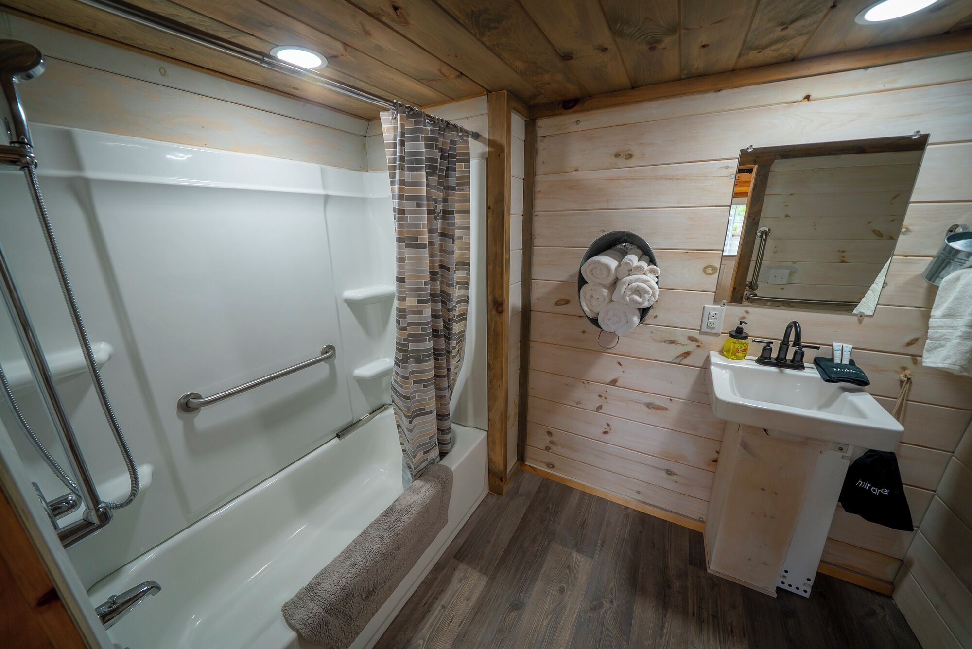 A bathroom with a shower, a sink, and a mirror.