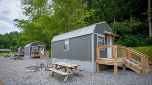 A small cabin with a wooden deck and picnic table. - 1 Room Cabin- " The Garage" (Robbinsville)