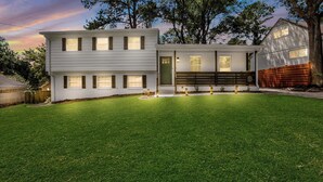 A modern two-story house with a well-maintained lawn and a wooden deck. - Rare Find Atlanta Retreat, this weekend just opened, Near Airpott+EV Charger (Atlanta)