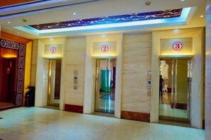 An interior with three elevator doors marked with numbers 1, 2, and 3. - Apollo Hotel (Yucheng)