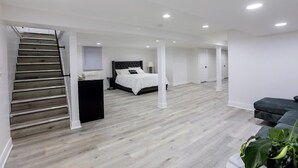 Un'ampia stanza con un letto, una scala e un'area salotto.