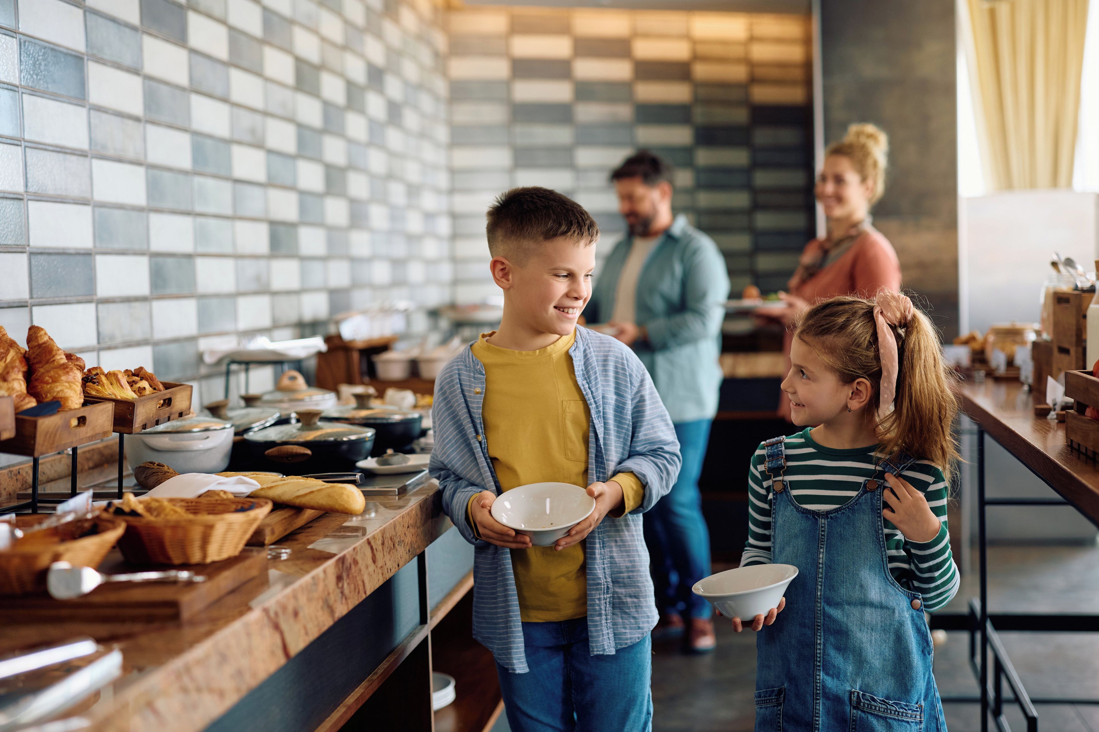 Ein reichhaltiges Frühstücksbuffet mit verschiedenen Speisen und einer interagierenden Familie.