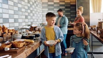 Ein reichhaltiges Frühstücksbuffet mit verschiedenen Speisen und einer interagierenden Familie.