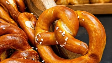 Un cuenco de madera lleno de pretzels y croissants.