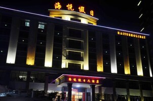 Un hotel con un cartel llamativo en la parte superior y una entrada bien iluminada.