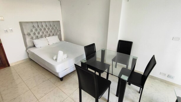 A hotel room with a bed, a glass dining table, and four chairs. - EM3-1 APARTAMENTO 1 HAB ZONA RESIDENCIAL (Cartagena)