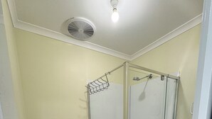 A bathroom with a toilet, a glass-enclosed shower, and a red rug. - Brandnew bedroom in a beautiful suburb  (Saint Albans)