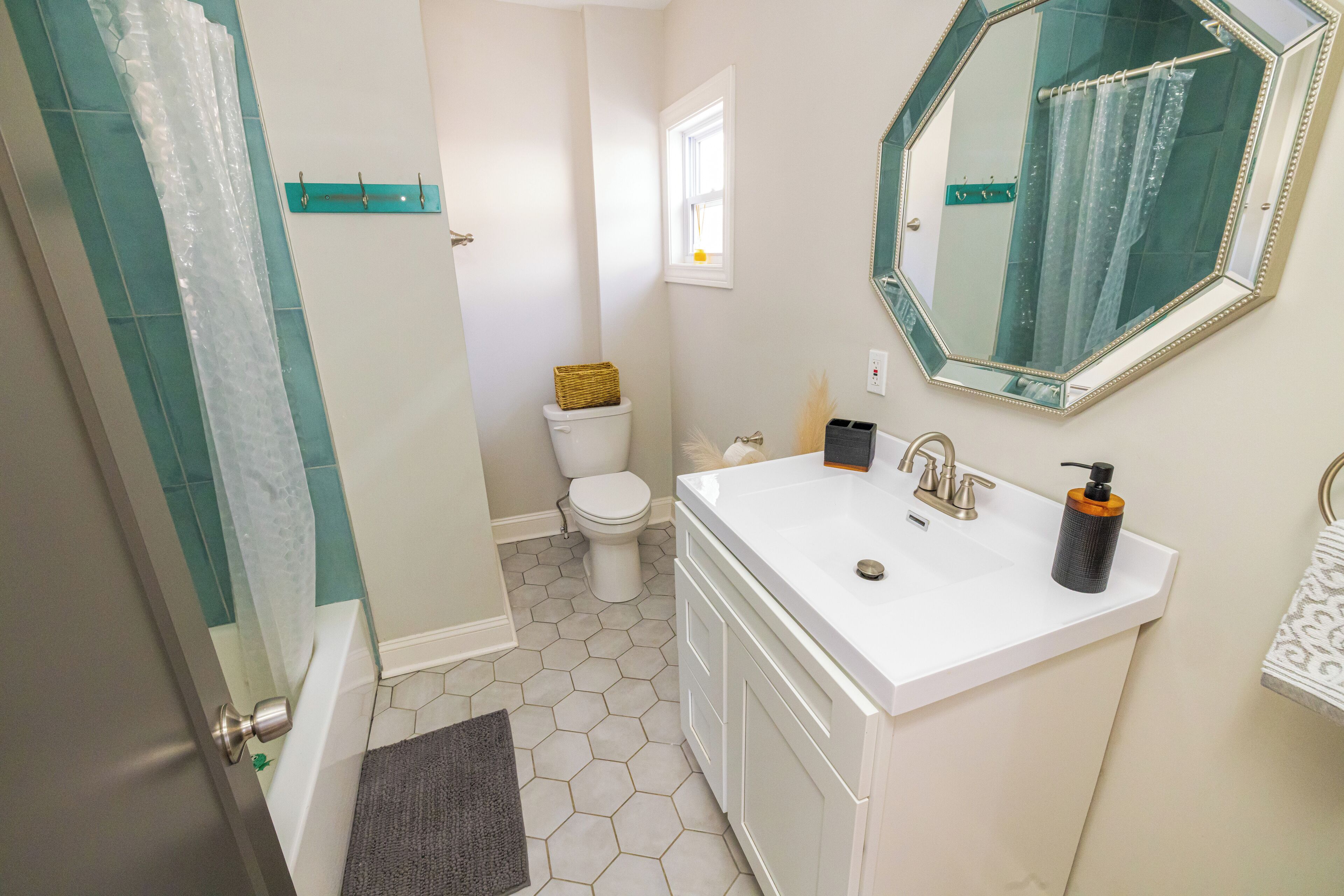 A bathroom with a white sink, a mirror, a toilet, and a shower area.
