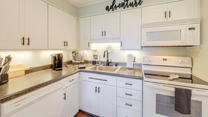 A kitchen with white cabinets, a microwave, and a sink. - Close to Hiking & Town! Peaceful Sugar Mtn Condo (Sugar Mountain)