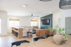A modern living room with a sofa, coffee table, and dining area.
