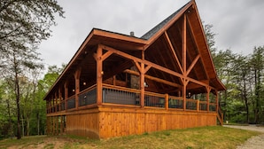 A wooden cabin with a sloped roof and a balcony.