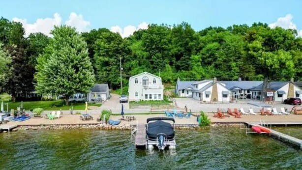 Ein Anwesen am Seeufer mit Steg, Haus und Boot.