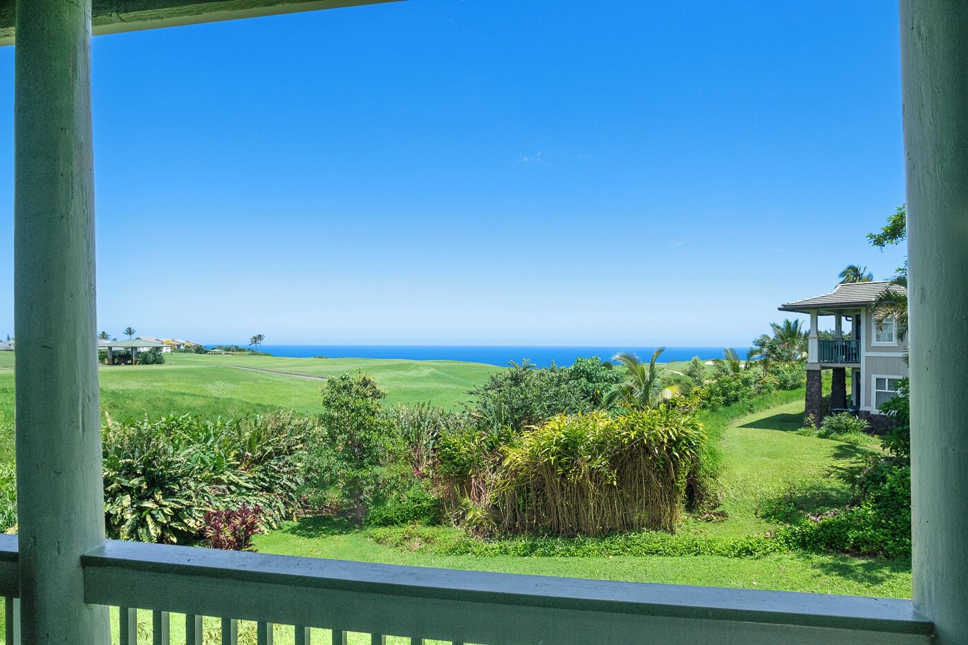Vista da un portico su un campo da golf, con una casa sullo sfondo.