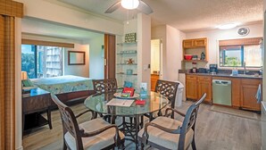 A hotel room with a bed, a dining table with chairs, a kitchen area, and a ceiling fan. - Sealodge B4 (Princeville)