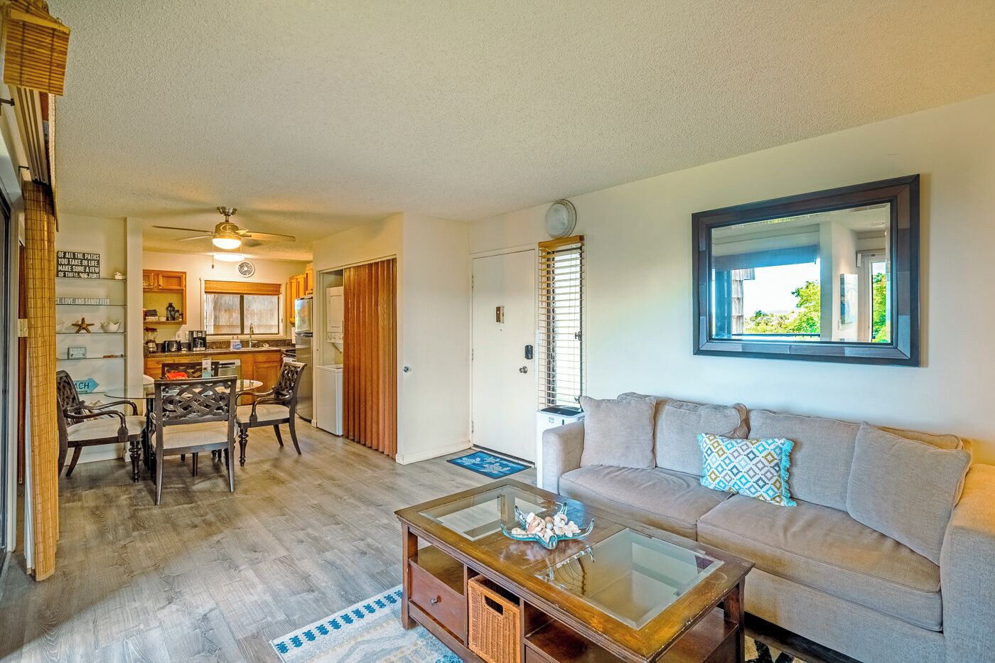 A living room with a sofa, coffee table, and dining area with chairs and a table.