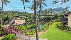 A tropical resort with a pool, palm trees, and a bridge. - Hanalei Colony Resort H4 (Hanalei)