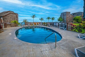 A swimming pool with lounge chairs and a view of the ocean. - Sealodge A6 (Princeville)