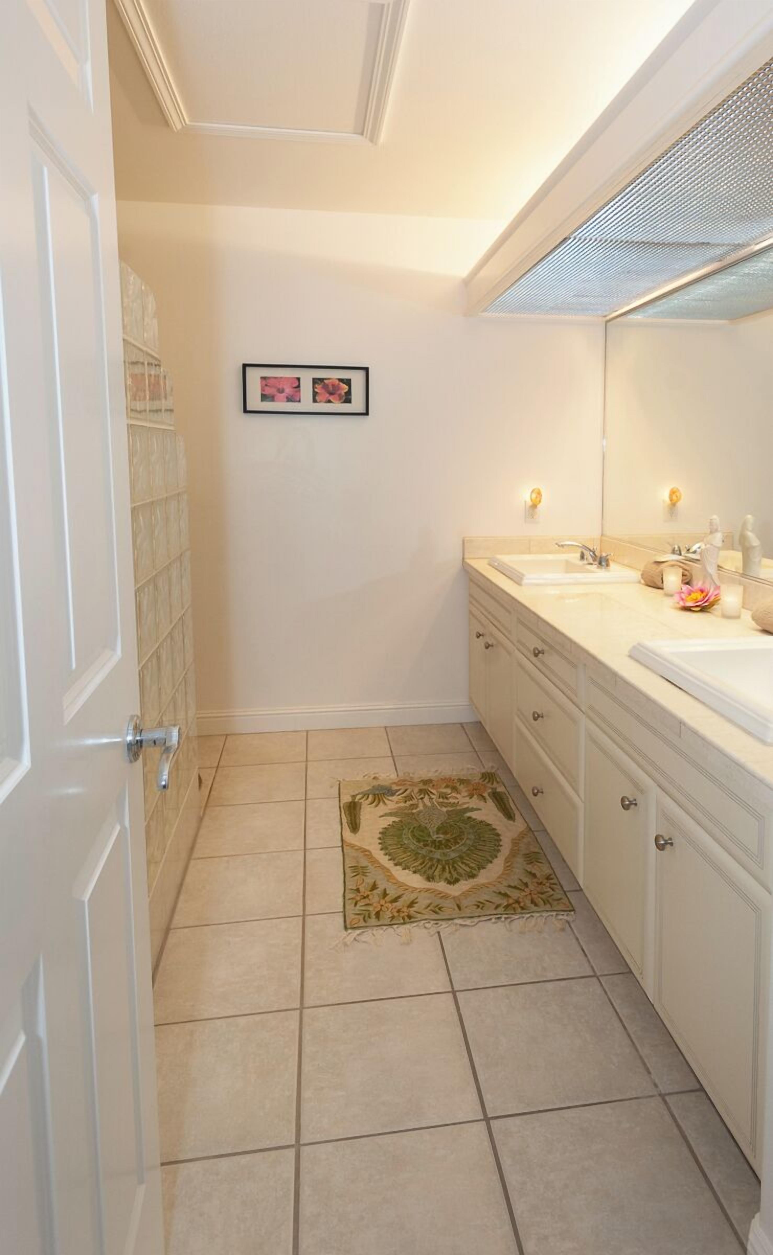 Un baño con dos lavamanos, un espejo y un tapete decorativo.