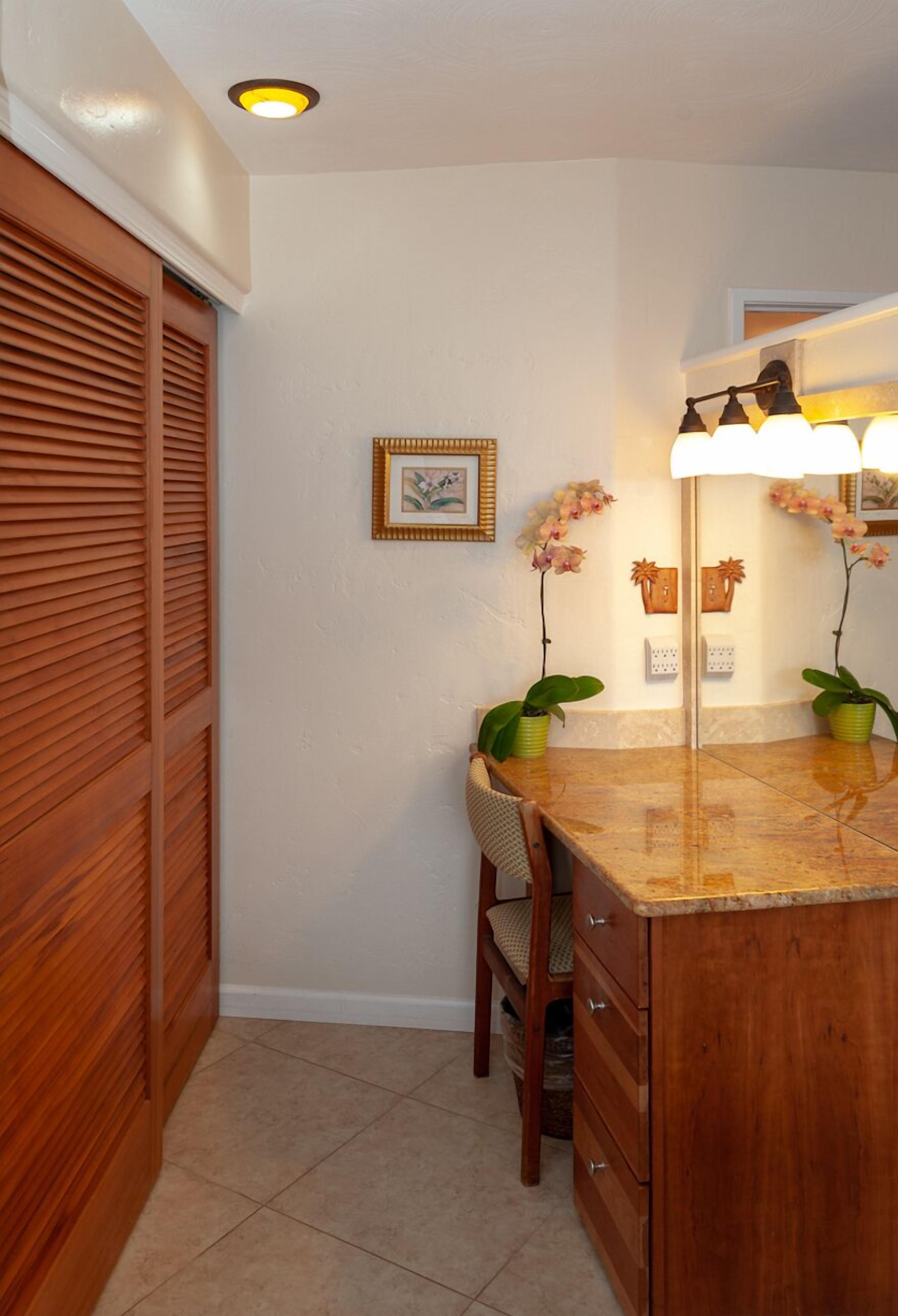A bathroom with a wooden vanity, a mirror, a towel rack, and a framed picture on the wall.