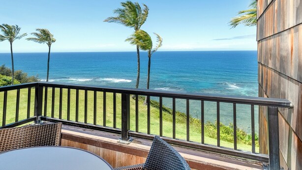 Ein Balkon mit Blick auf das Meer und Palmen.