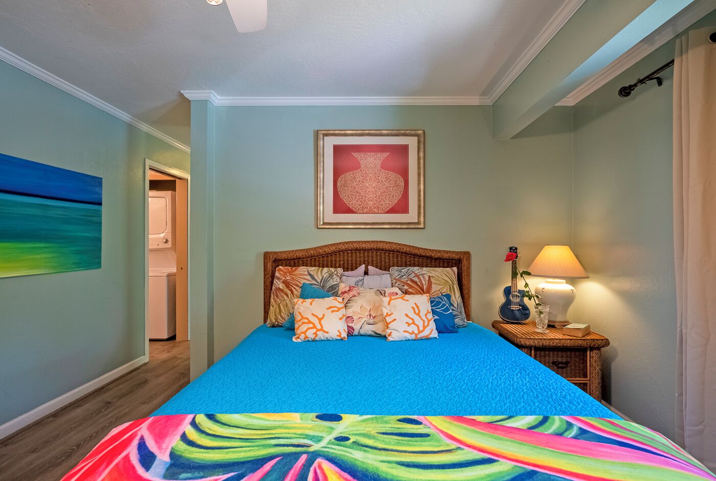 A bedroom with a bed, a nightstand, a lamp, and a framed picture on the wall.