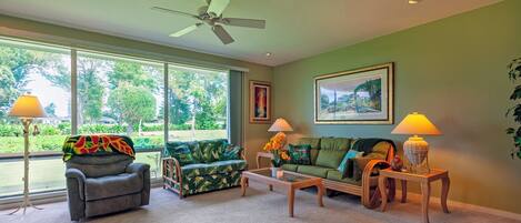 A living room with a ceiling fan, a sofa, a chair, and two lamps.