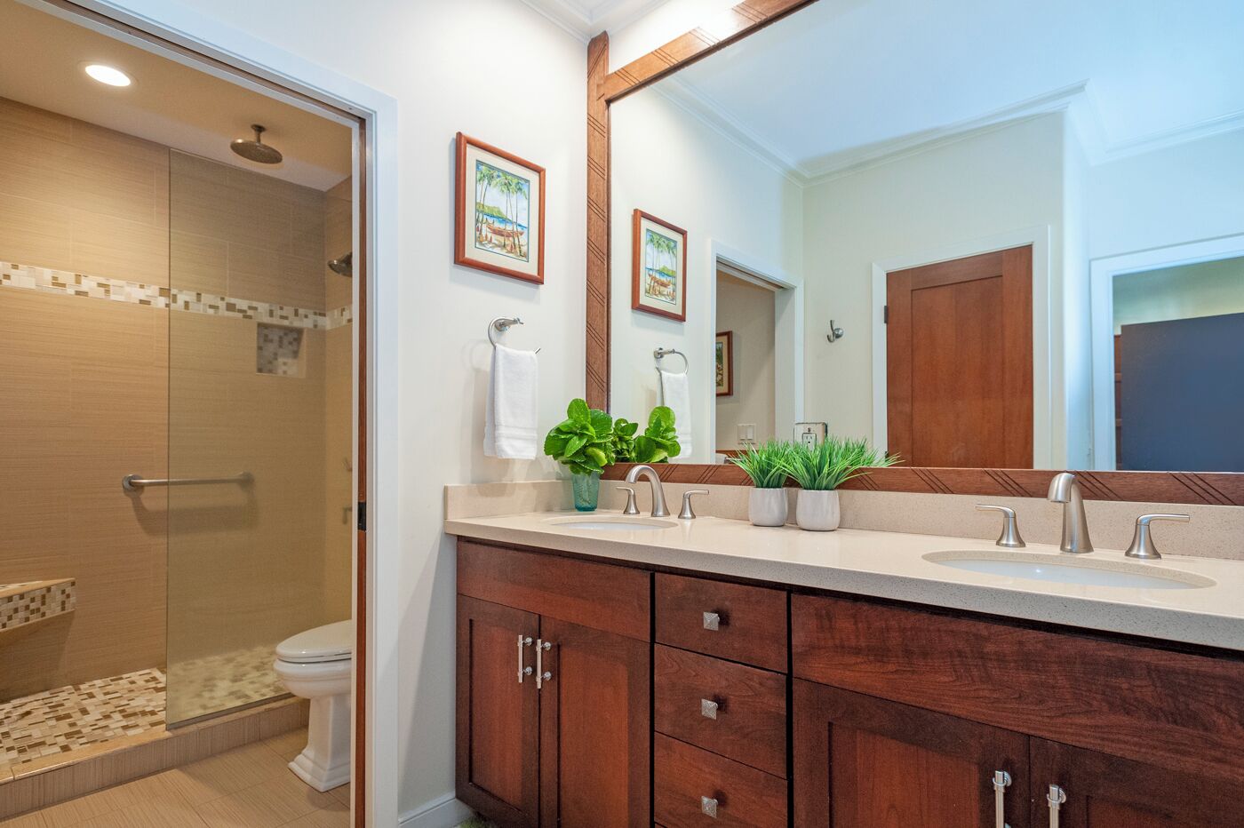 A modern bathroom with a walk-in shower, a large mirror, and wooden cabinets.