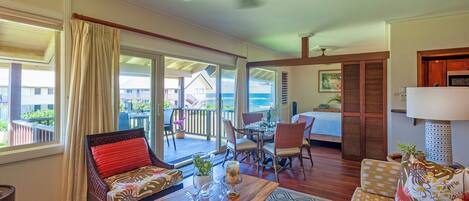 A spacious living area with a balcony, a dining table, and a sofa.