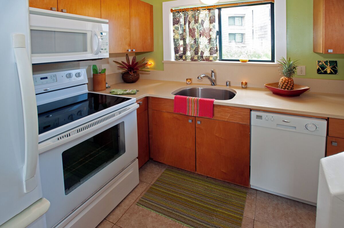 A kitchen with a microwave, oven, sink, and dishwasher.