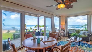 A spacious room with a large table and chairs, a ceiling fan, and a view of the ocean. - Hanalei Colony Resort I-1 (Hanalei)