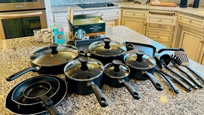 Una cocina con encimeras de granito, electrodomésticos de acero inoxidable y una variedad de utensilios de cocina.