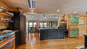 A modern kitchen with wooden flooring, a central island, and built-in cabinets.