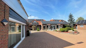 Een modern huis met een bakstenen gevel, grote ramen en een verharde oprit.