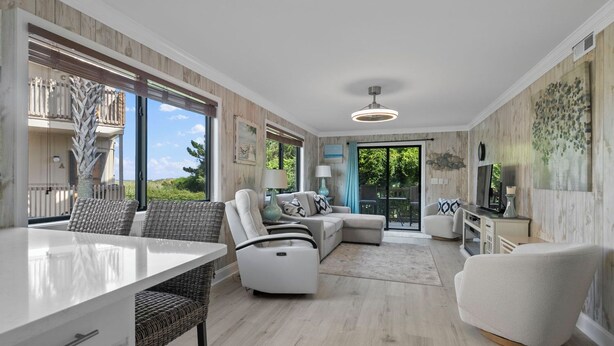 A spacious living area with a dining table, two sofas, and a TV.