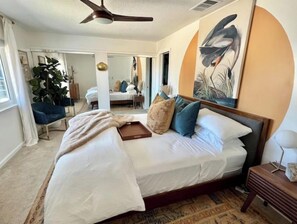 A bedroom with a large bed, a ceiling fan, a nightstand, and a painting of a bird. - The Wild Blue - Hot Tub & Few Min to Joshua Tree & Pioneertown (Yucca Valley)