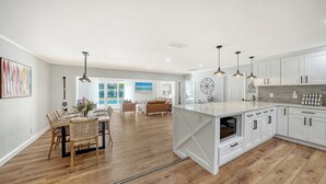 A spacious kitchen with white cabinets, a large island, and pendant lighting. - Heated Pool Retreat • 3BR • Minutes to Siesta Key & Downtown (Sarasota)