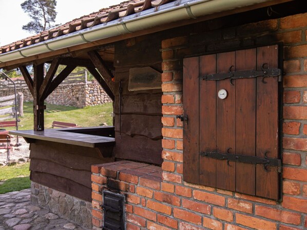 A rustic outdoor seating area with a brick wall and wooden beams.
