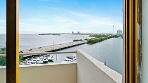 Ein Balkon mit Blick auf eine Marina, eine Brücke und entfernte Gebäude über dem Wasser.