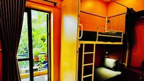 A room with a bunk bed, a sliding door leading to a balcony, and an air conditioning unit on the wall. - Autumn Hanoi House Bat Su (Hanoi)