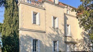 Un bâtiment à deux étages doté d’une façade symétrique, avec des fenêtres régulièrement espacées et une entrée centrale.