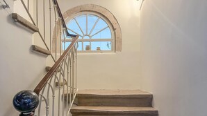 Un escalier avec une rampe en bois et une porte en verre en haut.