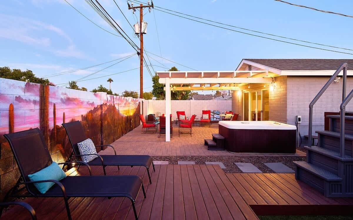 A patio with outdoor seating, a hot tub, and a covered area.
