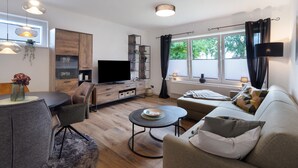 Una sala de estar moderna con una mesa de comedor, sofá y televisor.