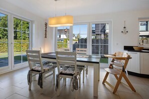 Een moderne keuken met een eettafel, stoelen en uitzicht op de omgeving.